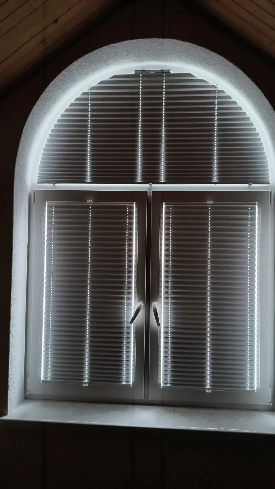 Plisy okienne M&G zamontowane na dużym oknie łukowym. Całkowicie zasłonięte skrzydła dolne oraz górne przeszklenie w kształcie półkola